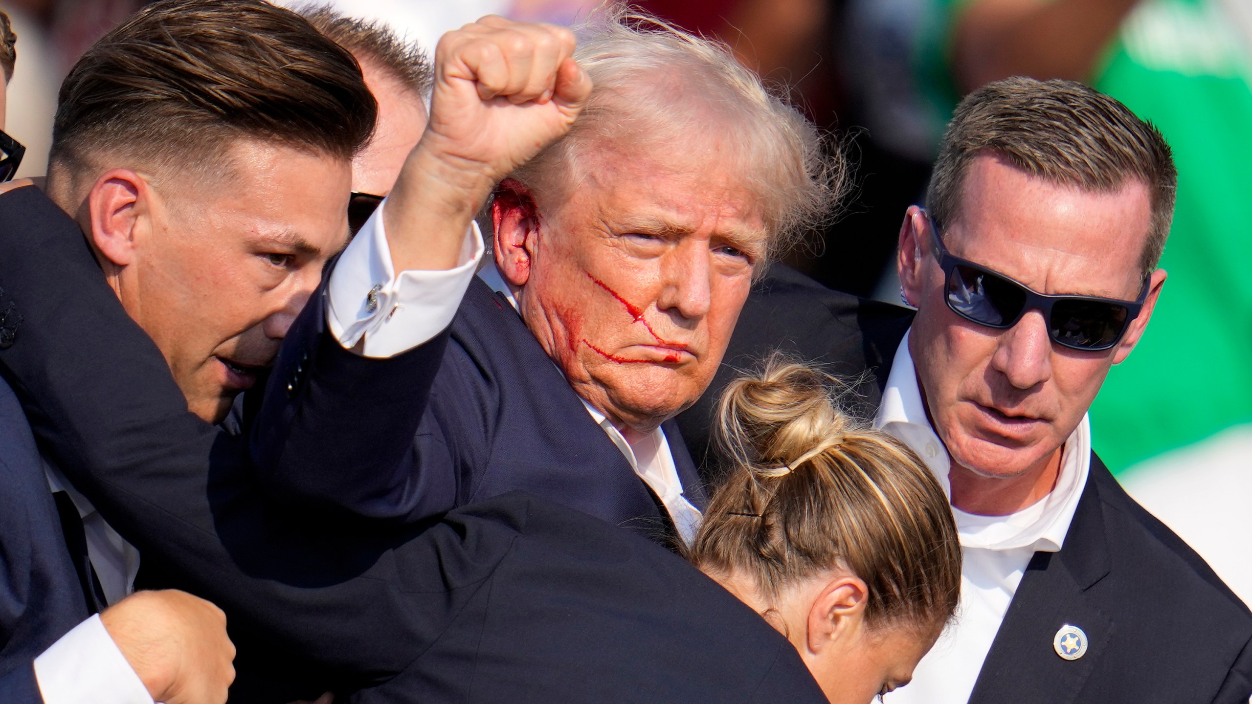 Republican presidential candidate former President Donald Trump is helped off the stage by U.S. Secret Service agents at a campaign event in Butler, Pa., on Saturday, July 13, 2024. (AP Photo/Gene J. Puskar)