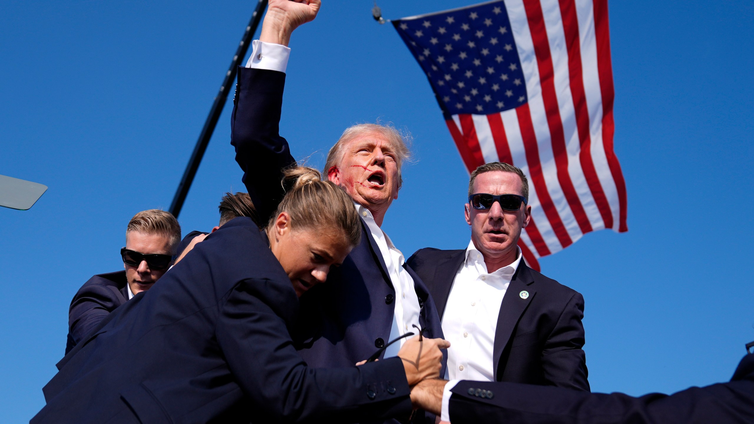 Republican presidential candidate former President Donald Trump is surrounded by U.S. Secret Service agents at a campaign rally.