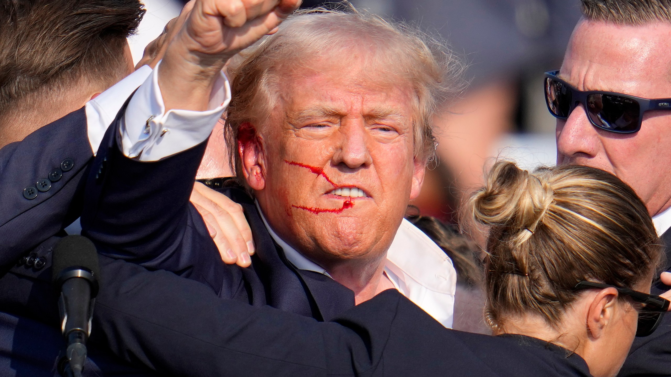 Republican presidential candidate former President Donald Trump reacts following an assassination attempt at a campaign event.