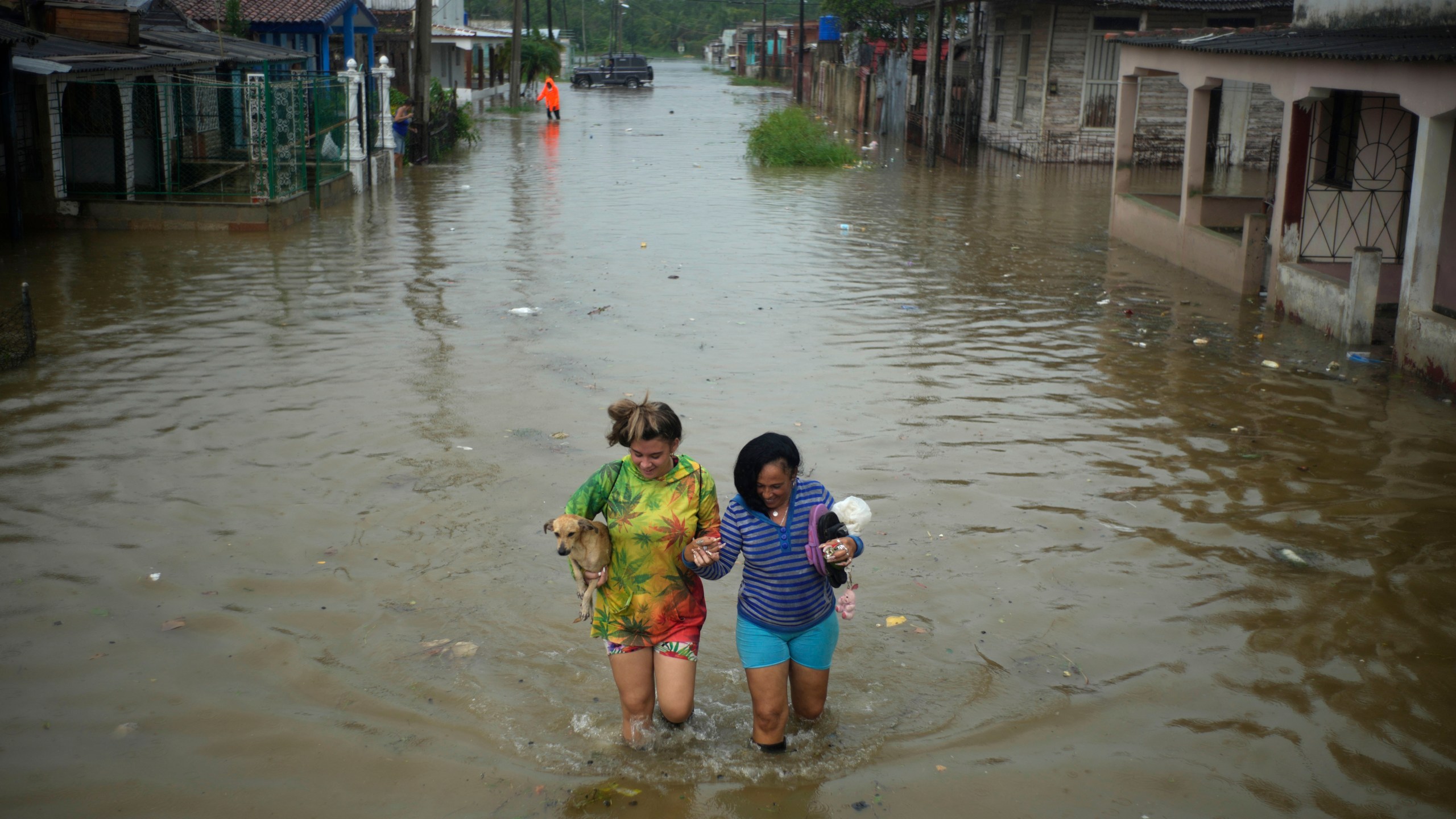 FILE - Residents wade through a street flooded by rains brought on by Hurricane Idalia, in Batabano, Cuba, Aug. 29, 2023. (AP Photo/Ramon Espinosa, File)