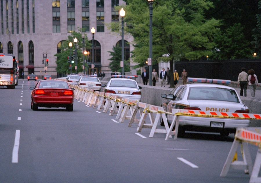 FILE - Cars and buses move along the lane of traffic on Pennsylvania Avenue near the White House in Washington, May 9, 1995, in the most visible tightening of presidential security since the Oklahoma City bombing. Protective details have grown in size, responsibility and technology over more than a century of the Secret Service protecting presidents. When the commander in chief leaves the White House, they're accompanied by a phalanx of Secret Service officers and agents. (AP Photo/Mark Wilson, File)