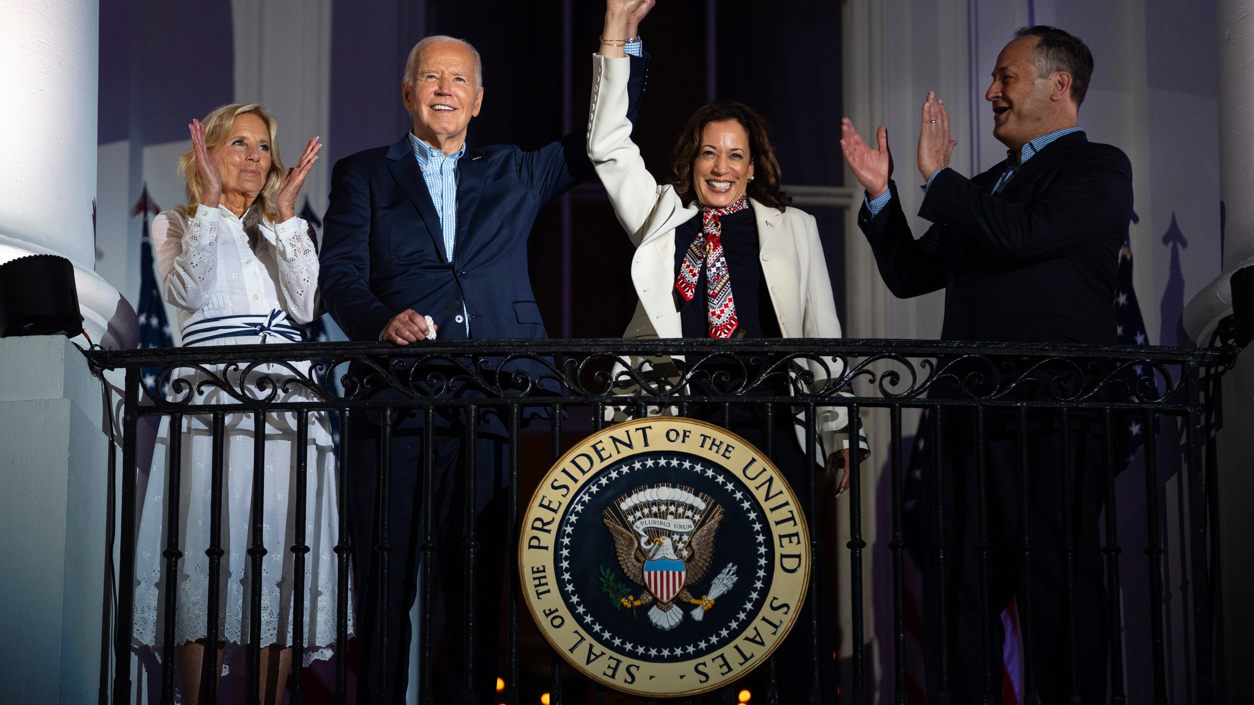 First lady Jill Biden, left, and second gentleman Douglass Emhoff, right, watch as President Joe Biden, center left, raises the hand of Vice President Kamala Harris as they view the Independence Day firework display over the National Mall from the balcony of the White House, July 4, 2024, in Washington. She's already broken barriers, and now Harris could soon become the first Black woman to head a major party's presidential ticket after President Joe Biden's ended his reelection bid. The 59-year-old Harris was endorsed by Biden on Sunday, July 21, after he stepped aside amid widespread concerns about the viability of his candidacy. (AP Photo/Evan Vucci, File)