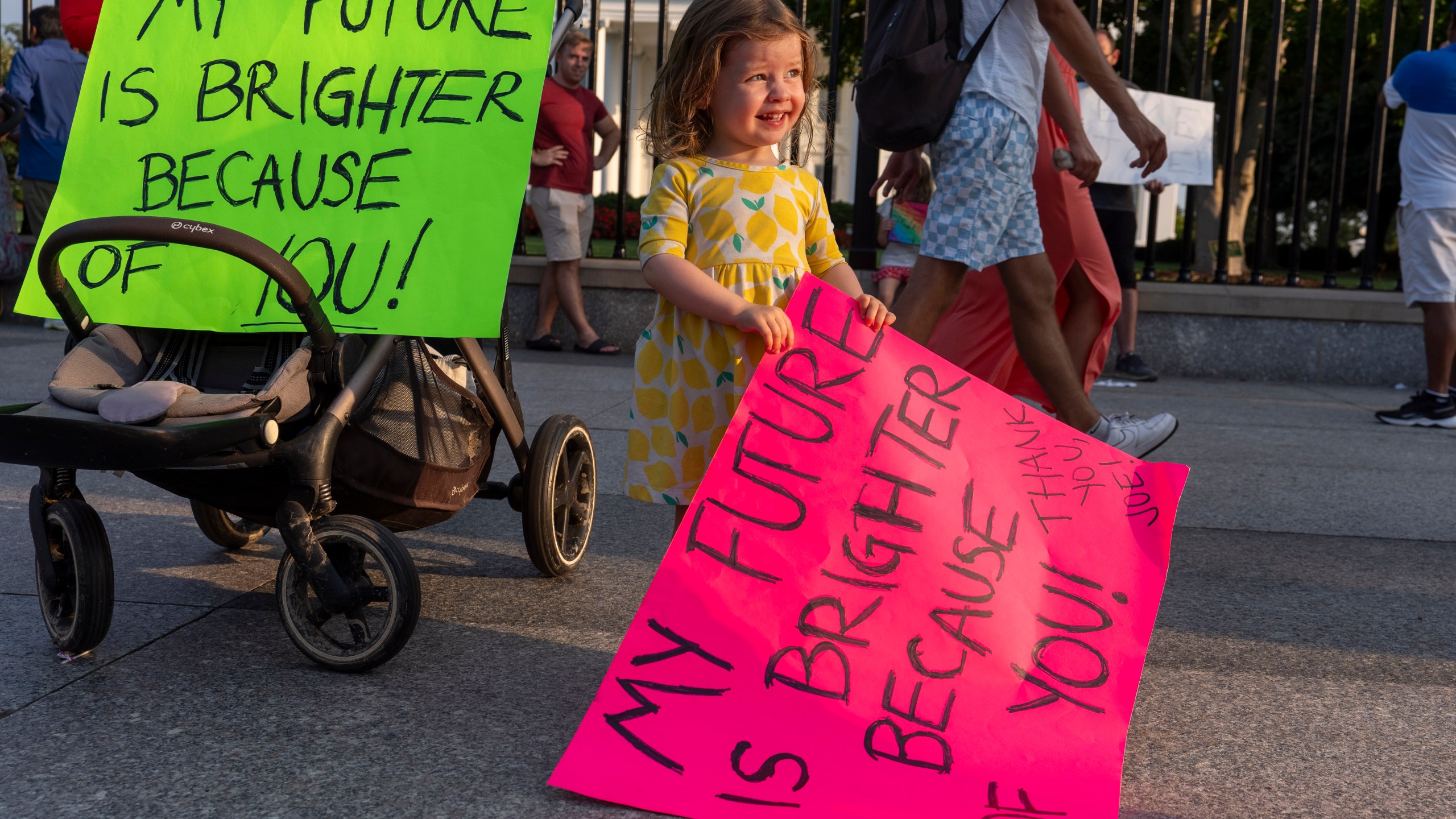 Louisa Monje, 2, from Washington, holds a sign in front of the White House, Sunday, July 21, 2024, in Washington. President Joe Biden dropped out of the 2024 race for the White House on Sunday, ending his bid for reelection following a disastrous debate with Donald Trump that raised doubts about his fitness for office just four months before the election. (AP Photo/Alex Brandon)