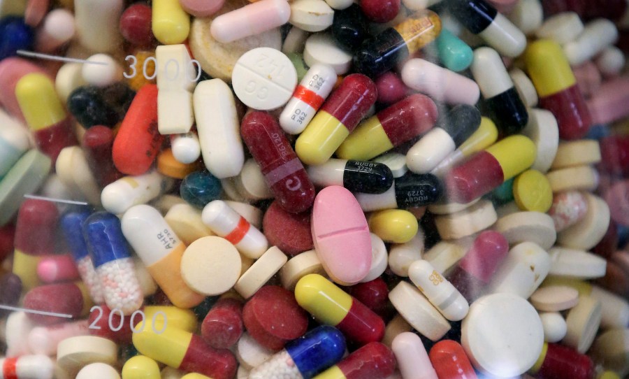 FILE - Prescription drugs are seen in a glass flask at a state laboratory in Taylorsville, Utah, on July 6, 2017. (AP Photo/Rick Bowmer, File)