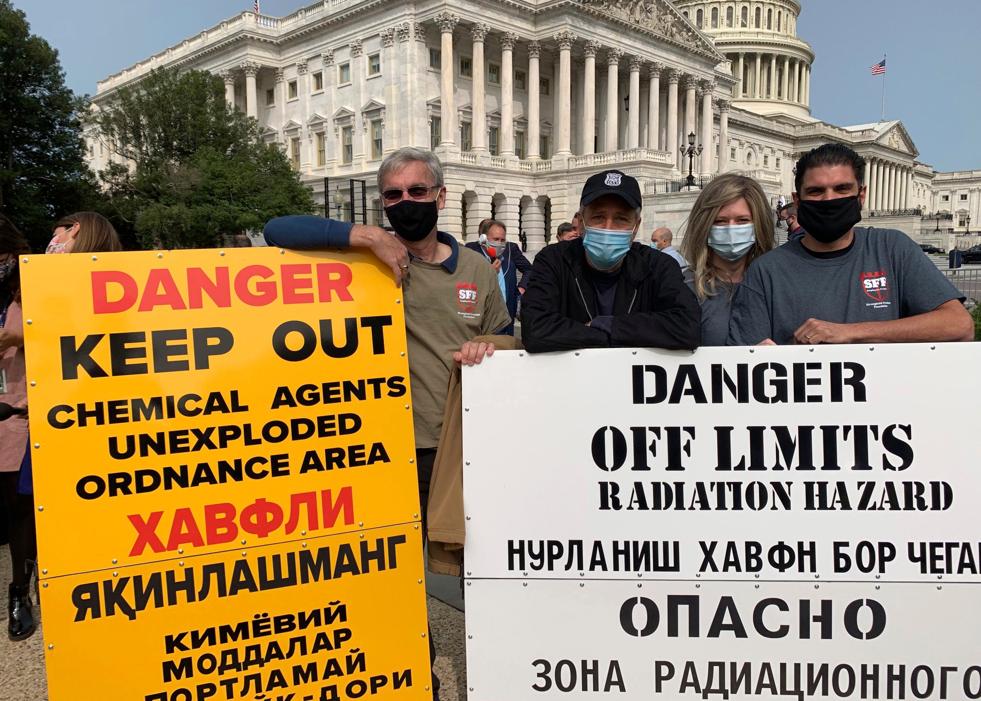 This image provided by Tara Copp shows Jon Stewart, host of "The Daily Show," third from right, as he stands with veterans and replica warning signs from K2, a former U.S. special operations base in Uzbekistan that was contaminated with the old Soviet chemical and nuclear weapons remnants, in front of the U.S. Capitol in 2020. Stewart began working with K2 veterans as part of his larger effort to get service members care for the toxic exposure-linked illnesses they got from their deployments during the wars in Iraq and Afghanistan. (Tara Copp via AP)