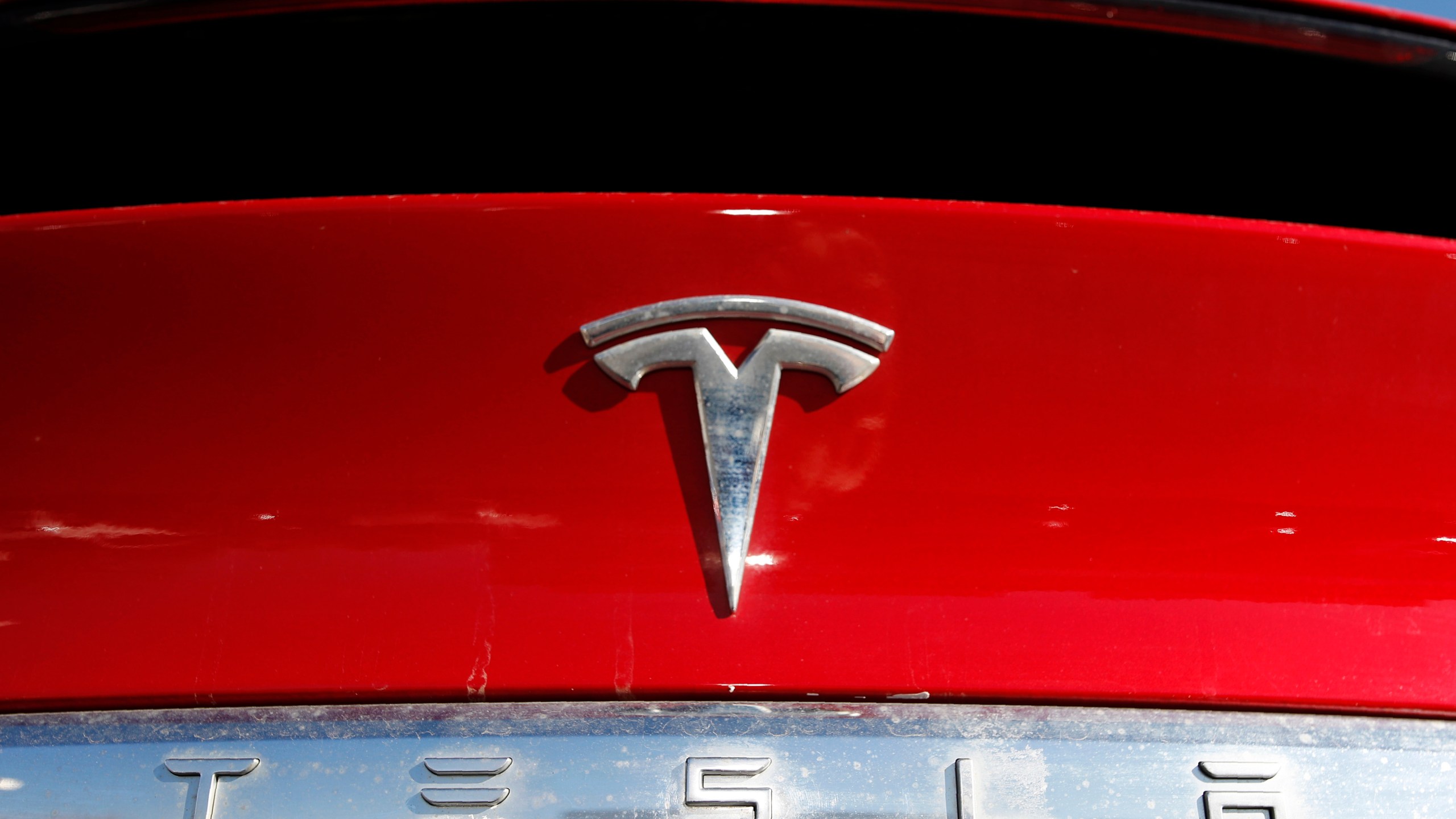FILE - The Tesla logo appears on an unsold 2020 Model X at a dealership, Feb. 2, 2020, in Littleton, Colo. Tesla's second-quarter net income fell 45% compared with a year ago as the company's global electric vehicle sales tumbled despite price cuts and low-interest financing. (AP Photo/David Zalubowski, File)