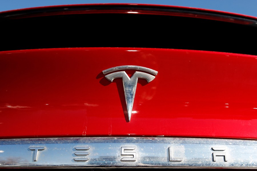 FILE - The Tesla logo appears on an unsold 2020 Model X at a dealership, Feb. 2, 2020, in Littleton, Colo. Tesla's second-quarter net income fell 45% compared with a year ago as the company's global electric vehicle sales tumbled despite price cuts and low-interest financing. (AP Photo/David Zalubowski, File)