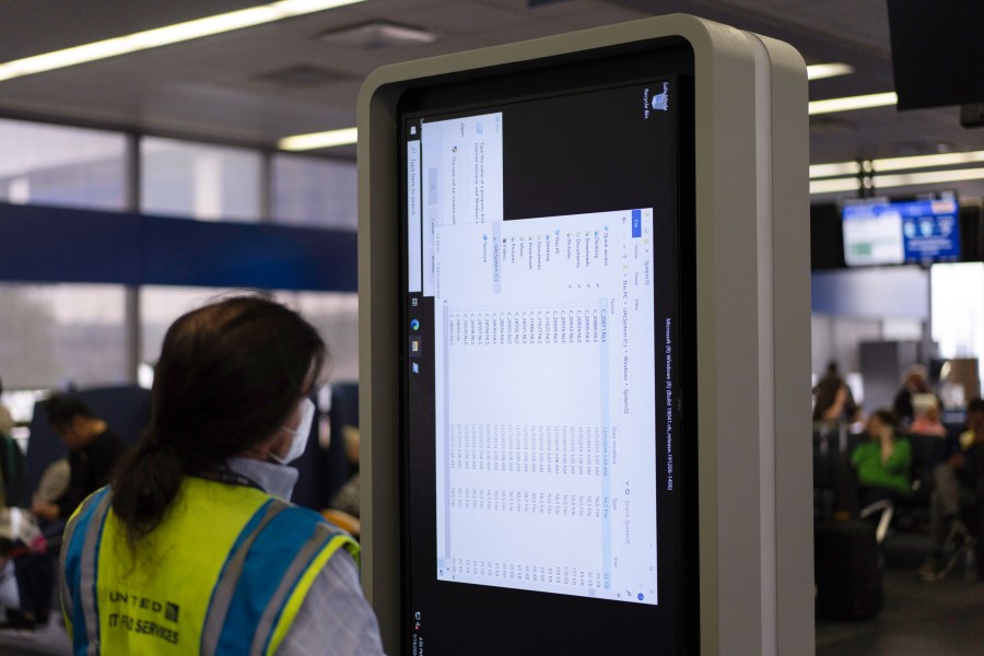 A technician works on an information display near United Airlines gates at Chicago O'Hare International Airport in Chicago, Friday, July 19, 2024, after a faulty CrowdStrike update caused a major internet outage for computers running Microsoft Windows. (AP Photo/Carolyn Kaster)