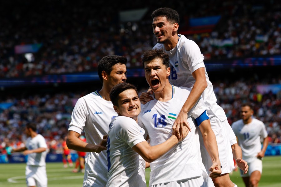 Uzbekistan's Eldor Shomurodov, centre, celebrates with teammates after scoring his team's first goal during the men's group C match between Uzbekistan and Spain at the Parc des Princes during the 2024 Summer Olympics, Wednesday, July 24, 2024, in Paris, France. (AP Photo/Aurelien Morissard)