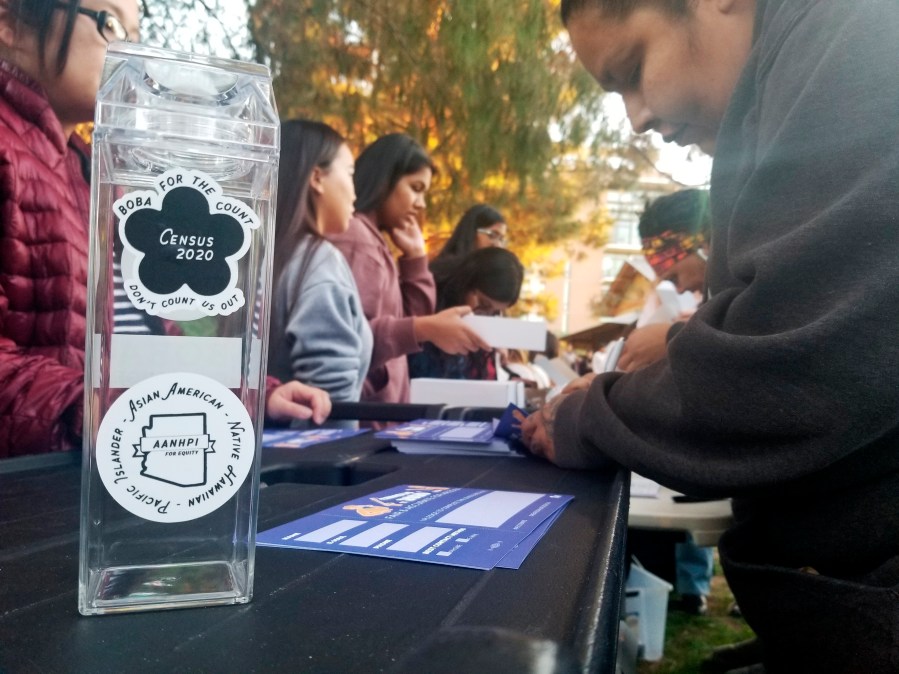 FILE - A woman fills out a pledge card for the U.S. Census in exchange for a reusable boba tea carton at a boba drink competition in Phoenix on Jan. 3, 2020. According to a new study released in June 2024, adding a citizenship question to the census reduces the participation of people who aren’t U.S. citizens. (AP Photo/Terry Tang, File)