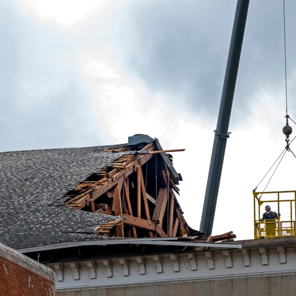 Demolition and property recovery workers are lifted into the wrecked framework of the First Presbyterian Church in Rome, N.Y., Tuesday, July 23, 2024, as salvage operations continue following an EF2 tornado that touched down one week earlier in the city's population center. Residents are vowing to rebuild. But some of the damage was so severe that the path forward is uncertain for many in this old manufacturing city, where people are more accustomed to digging out from snowstorms than from piles of rubble. (AP Photo/Craig Ruttle)