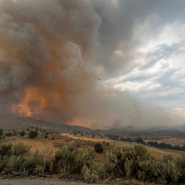 In this image provided by the U.S. Department of Agriculture Forest Service, smoke rises from a wildfire on Monday, July 22, 2024, near Durkee, Ore. In eastern Oregon, evacuation orders were lifted Thursday for the city of Huntington, population 500, after a severe thunderstorm late Wednesday brought some rain and cooler temperatures to the nearly 630 square miles (1,630 square kilometers) burned by the Durkee Fire, the nation's biggest, and another nearby blaze. (Brett Brown/USDA Forest Service via AP)