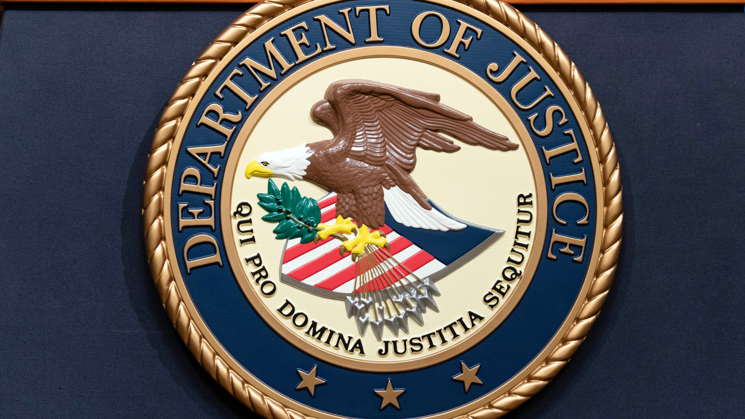 FILE - The Department of Justice seals is seen during a news conference at the Department of Justice in Washington, Tuesday, May 16, 2023. A federal grand jury in California has charged activist short seller Andrew Left with multiple counts of securities fraud, Friday, July 26, 2024, for a $16 million stock market manipulation scheme. (AP Photo/Jose Luis Magana, file)