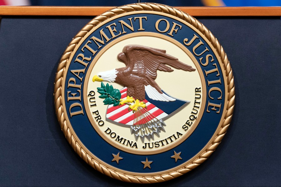 FILE - The Department of Justice seals is seen during a news conference at the Department of Justice in Washington, Tuesday, May 16, 2023. A federal grand jury in California has charged activist short seller Andrew Left with multiple counts of securities fraud, Friday, July 26, 2024, for a $16 million stock market manipulation scheme. (AP Photo/Jose Luis Magana, file)