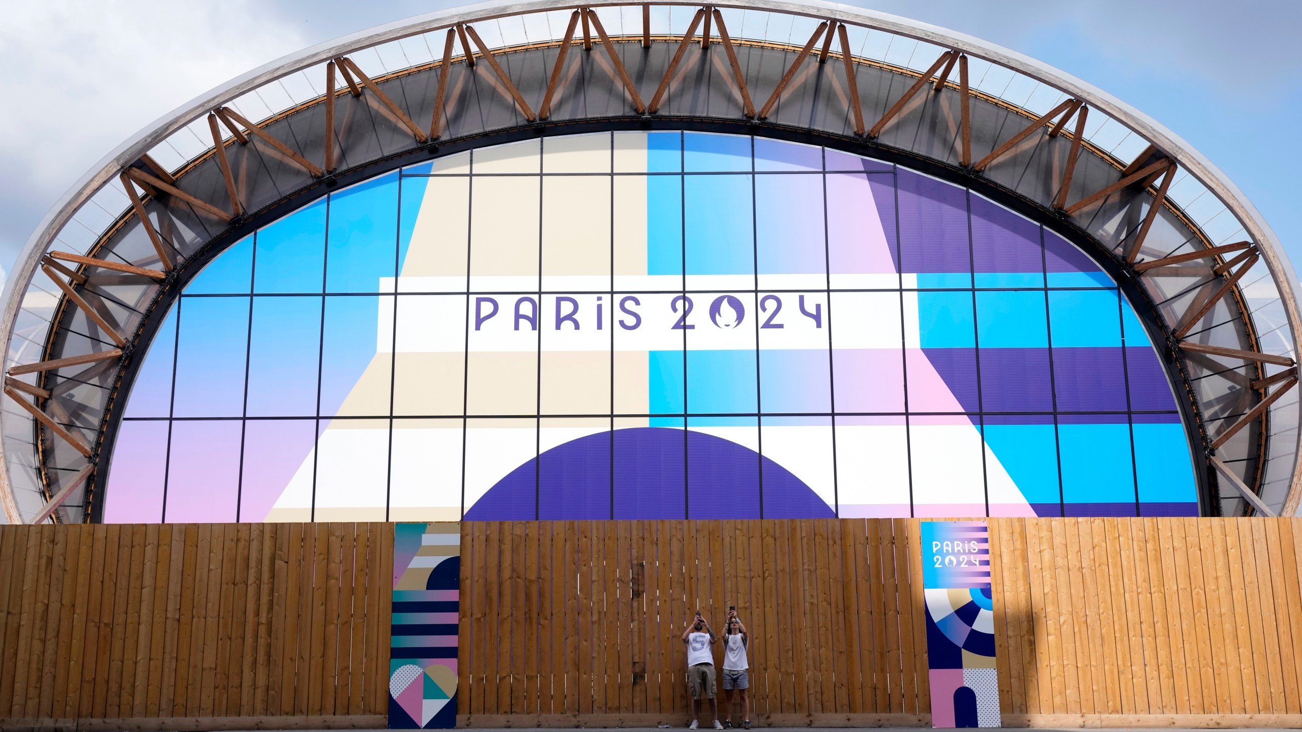 Tourists photograph near the Champ-de-Mars Arena, ahead of the 2024 Summer Olympics, Wednesday, July 24, 2024, in Paris, France. (AP Photo/Eugene Hoshiko)