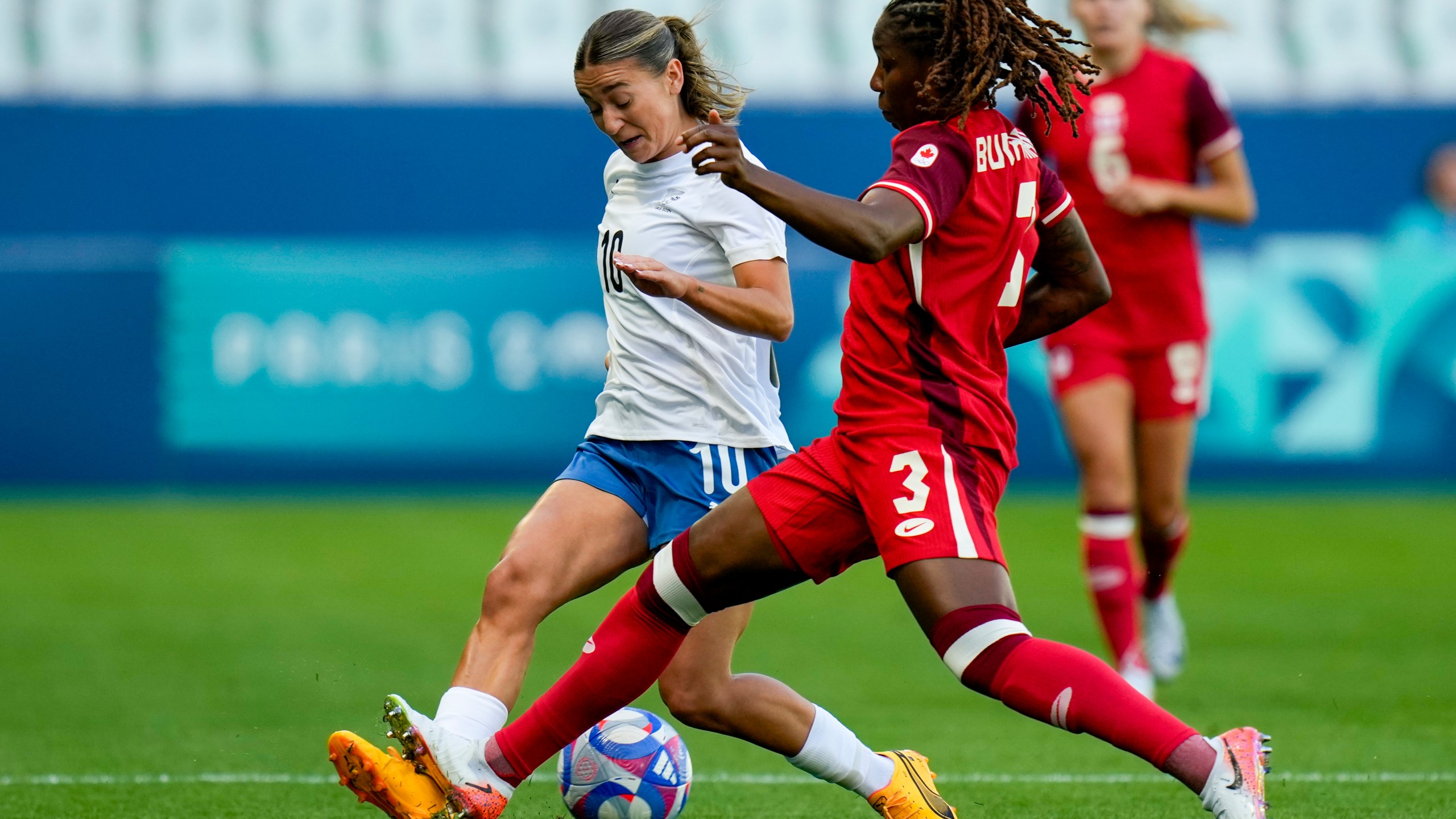 New Zealand's Indiah-Paige Riley, left, and Canada's Kadeisha Buchanan compete for the ball during the women's Group A soccer match between Canada and New Zealand at Geoffroy-Guichard stadium during the 2024 Summer Olympics, Thursday, July 25, 2024, in Saint-Etienne, France. (AP Photo/Silvia Izquierdo)