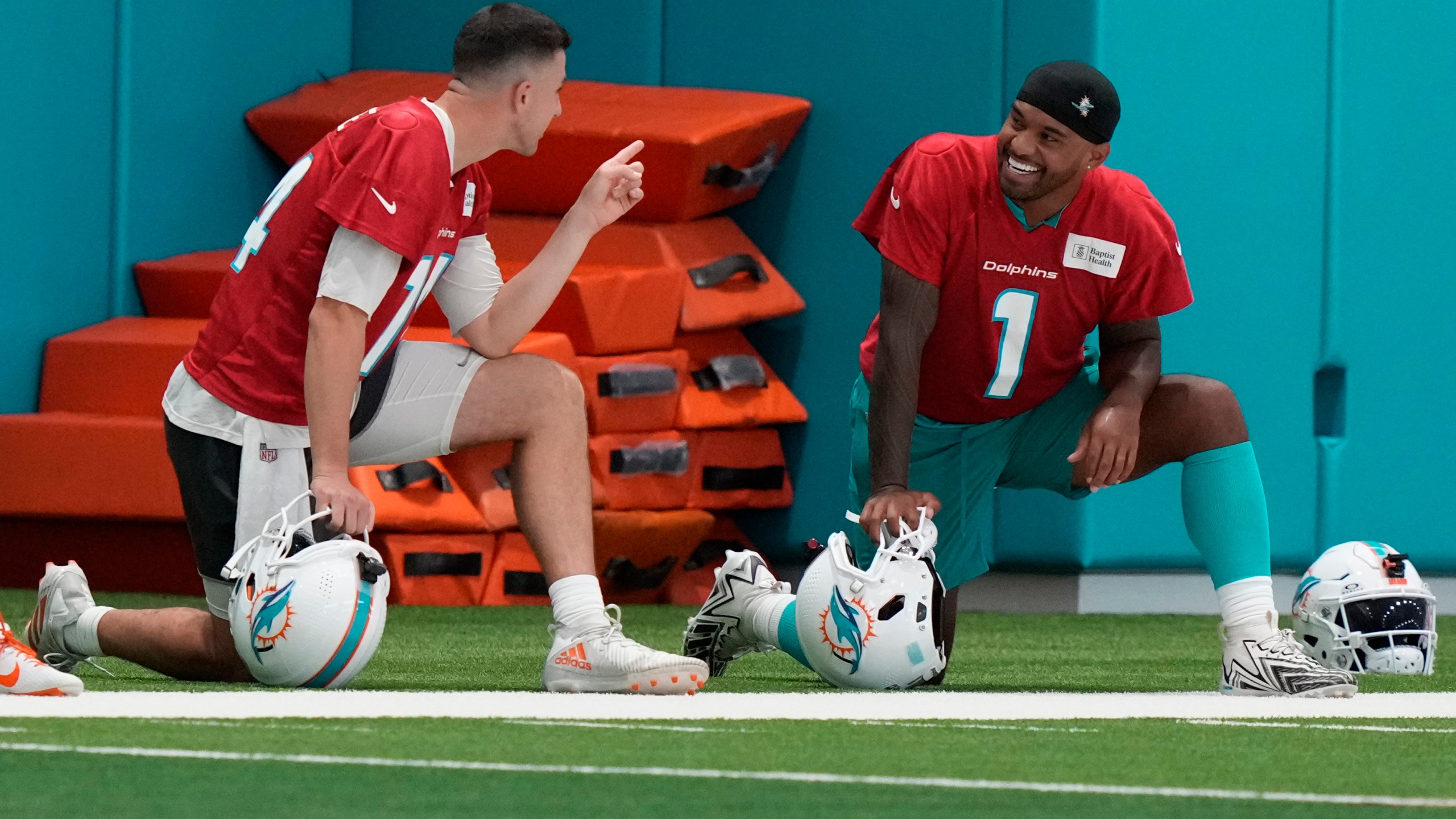 Miami Dolphins quarterback Mike White, left, talks with quarterback Tua Tagovailoa (1) during NFL football training camp, Wednesday, July 24, 2024, in Miami Gardens, Fla. (AP Photo/Lynne Sladky)