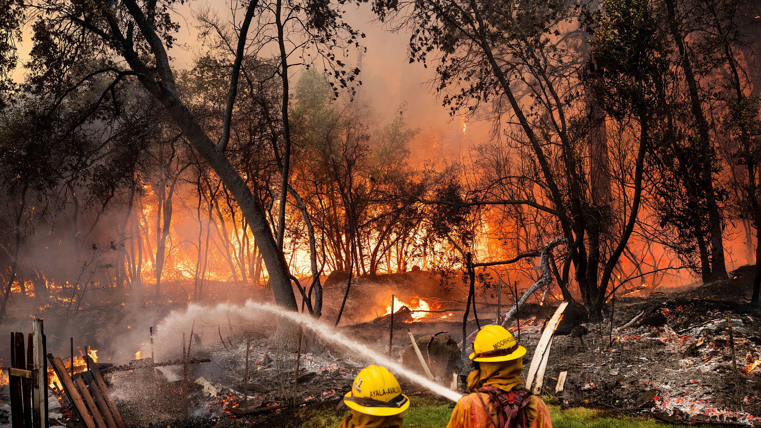 Firefighters spray water while battling the Park Fire in the Cohasset community of Butte County, Calif., on Thursday, July 25, 2024. The crew was able to keep flames from reaching the mobile home they were protecting. (AP Photo/Noah Berger)