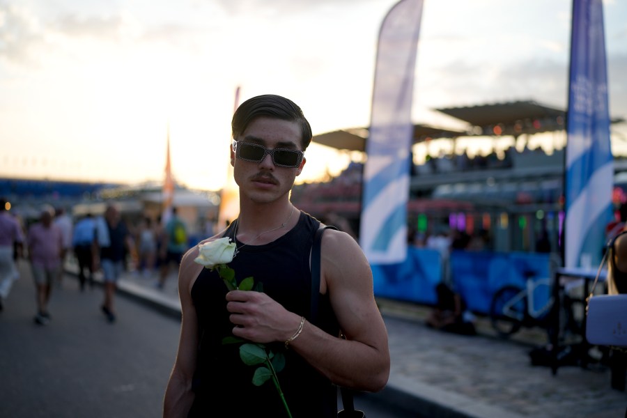 Robin Labarrere holds a flower after performing at the opening of Pride House, the safe space for the LGBT+ community of athletes, during the 2024 Summer Olympics, Monday, July 29, 2024, in Paris, France. (AP Photo/Natacha Pisarenko)