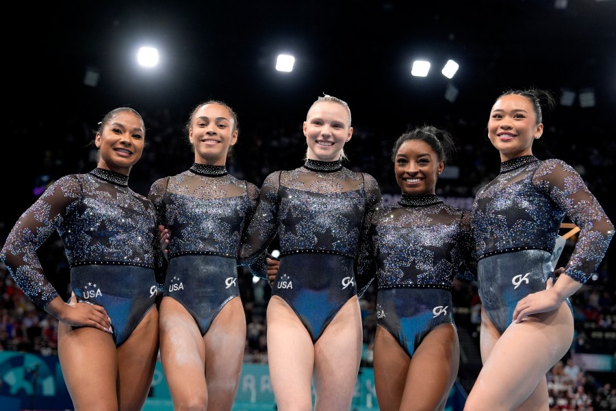 Team USA from left to right, Jordan Chiles, Hezly Rivera, Jade Carey, Simone Biles and Sunisa Lee, right, pose for photos after competing in a women's artistic gymnastics qualification round at Bercy Arena at the 2024 Summer Olympics, Sunday, July 28, 2024, in Paris, France. (AP Photo/Charlie Riedel)