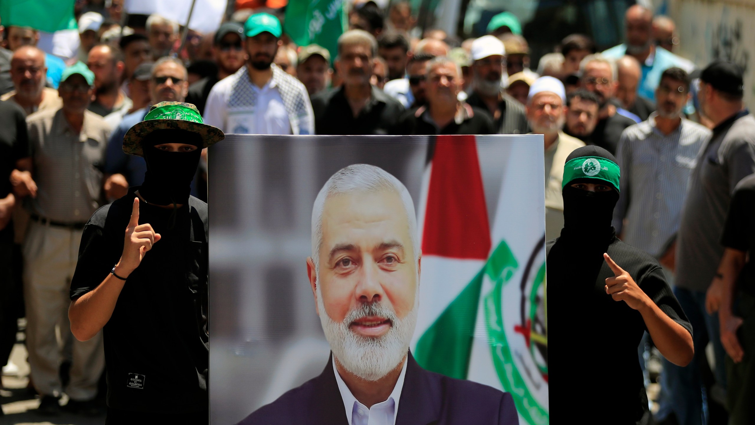 Hamas members hold a poster of Hamas political chief Ismail Haniyeh during a protest to condemn his killing, at al-Bass Palestinian refugee camp, in the southern port city of Tyre, Lebanon, Wednesday, July 31, 2024. Haniyeh, Hamas' political chief in exile who landed on Israel's hit list after the militant group staged its surprise Oct. 7 attacks, was killed in an airstrike in the Iranian capital early Wednesday. (AP Photo/Mohammed Zaatari)