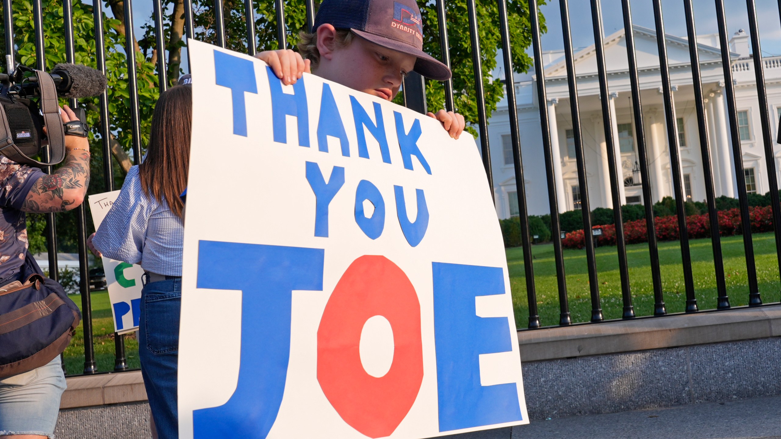 FILE - Hugh Kieve, 10, of Washington, holds a sign outside the White House in Washington, Sunday, July 21, 2024, as he and his family come out to show support for President Joe Biden. Ten days since ending his reelection campaign after losing the confidence of his party, Biden is still coming to terms with the stunning political whiplash he — and the country — experienced. The Democratic president is privately smarting over those who orchestrated the end of his political career and the even swifter embrace of Vice President Kamala Harris as his replacement.(AP Photo/Susan Walsh, File)