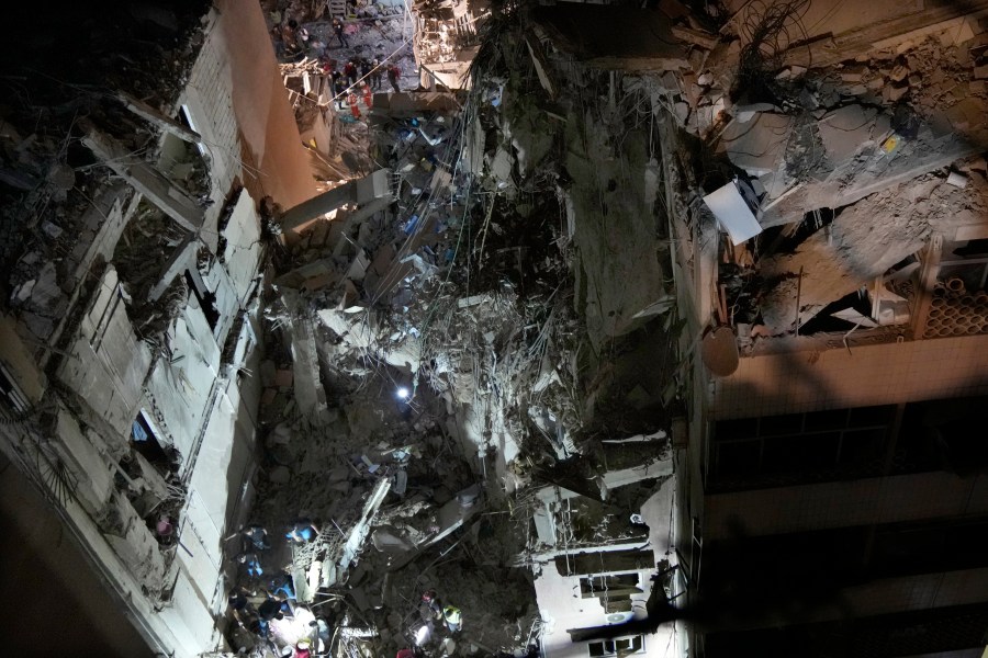 Civil defence workers check for victims between the wreckage of destroyed buildings that were hit by an Israeli airstrike in the southern suburbs of Beirut, Lebanon, Tuesday, July 30, 2024. An Israeli airstrike hit Hezbollah's stronghold south of Beirut Tuesday evening causing damage, a Hezbollah official and the group's TV station said. (AP Photo/Hussein Malla)