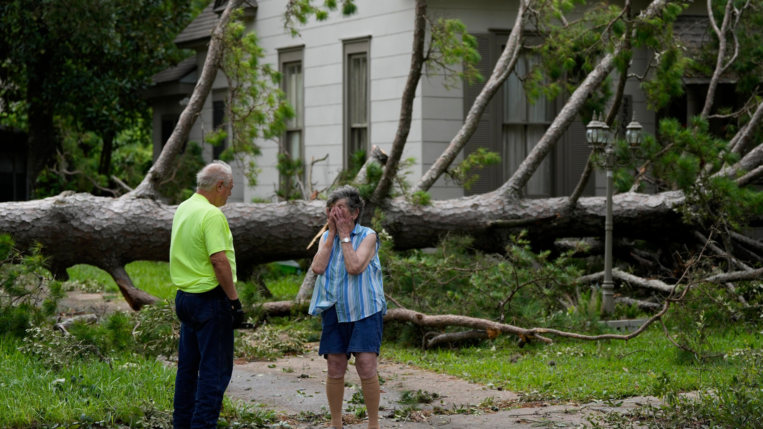 Jackie Jecmenek, right, talks with city worker Bobby Head as she stands in front of her neighbor's home after Beryl passed, Monday, July 8, 2024, in Bay City, Texas.