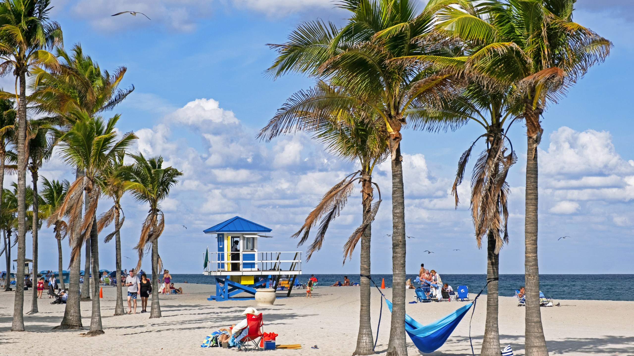 Tourists and lifeguard tower on Surfside Beach along the Atlantic Ocean in Miami-Dade County, Florida