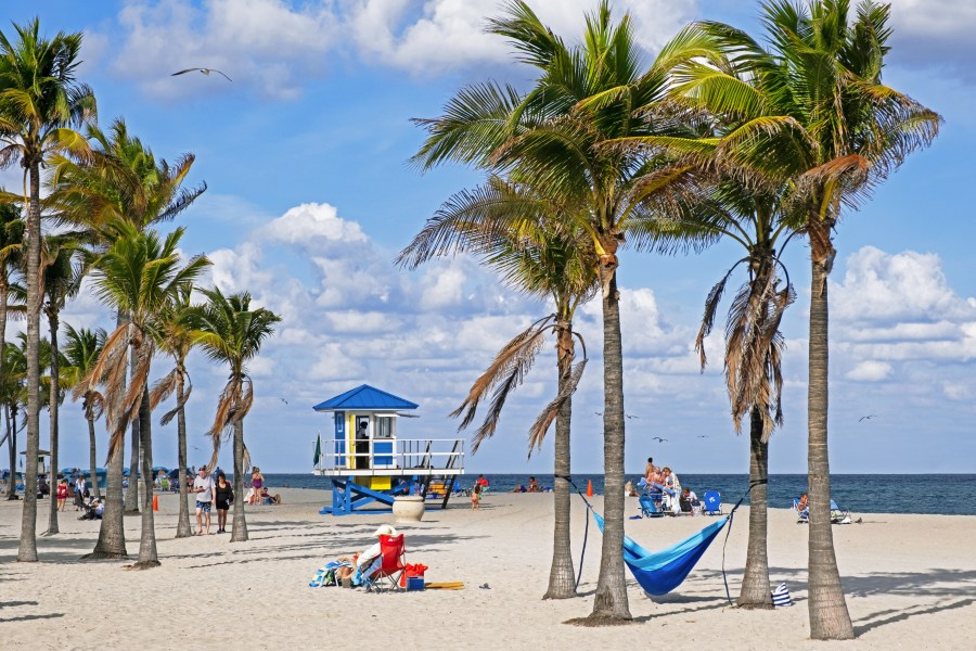 Tourists and lifeguard tower on Surfside Beach along the Atlantic Ocean in Miami-Dade County, Florida