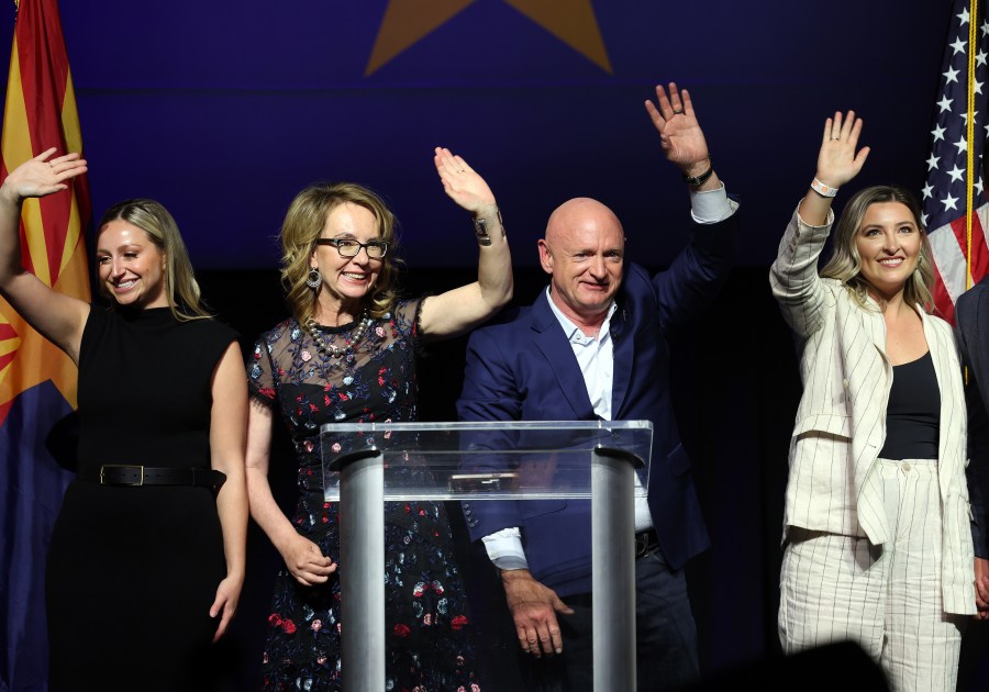 Mark Kelly and his wife Gabby Giffords, joined by their daughters Claudia and Claire, wave to supporters.