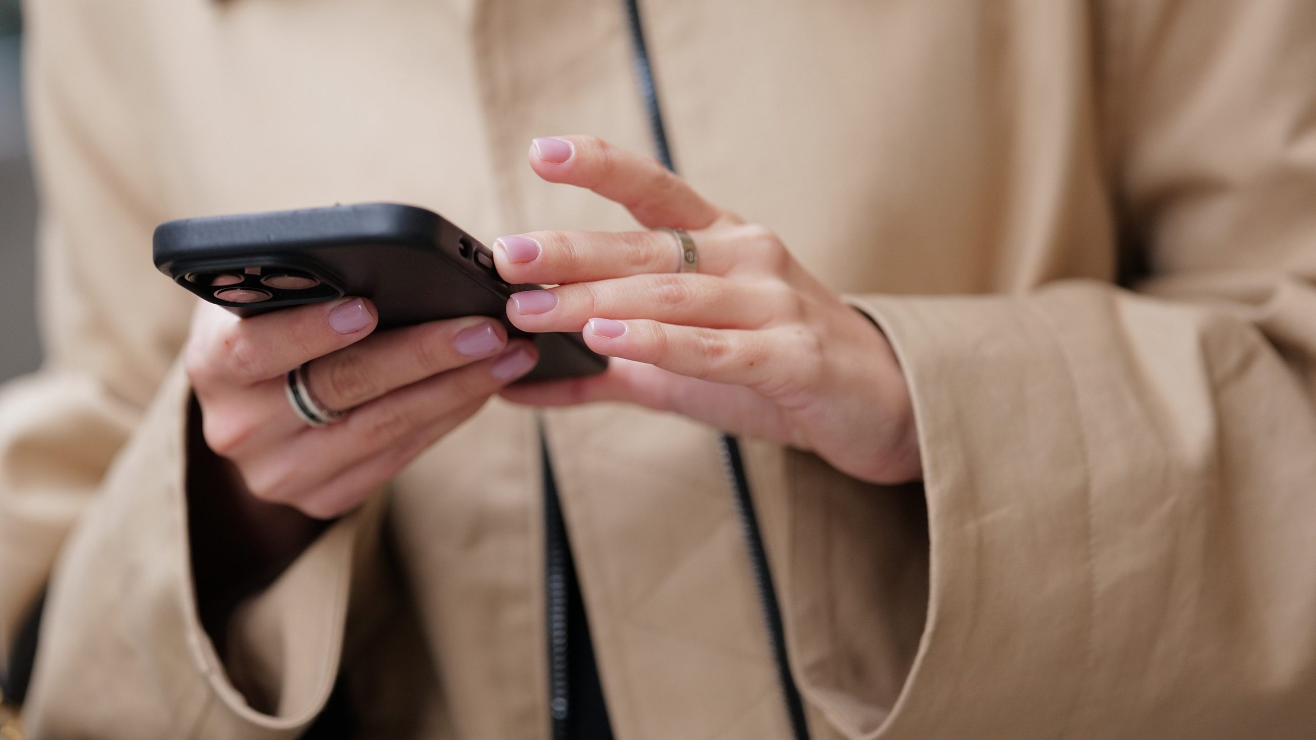 Woman with pink manicure texts on a phone.