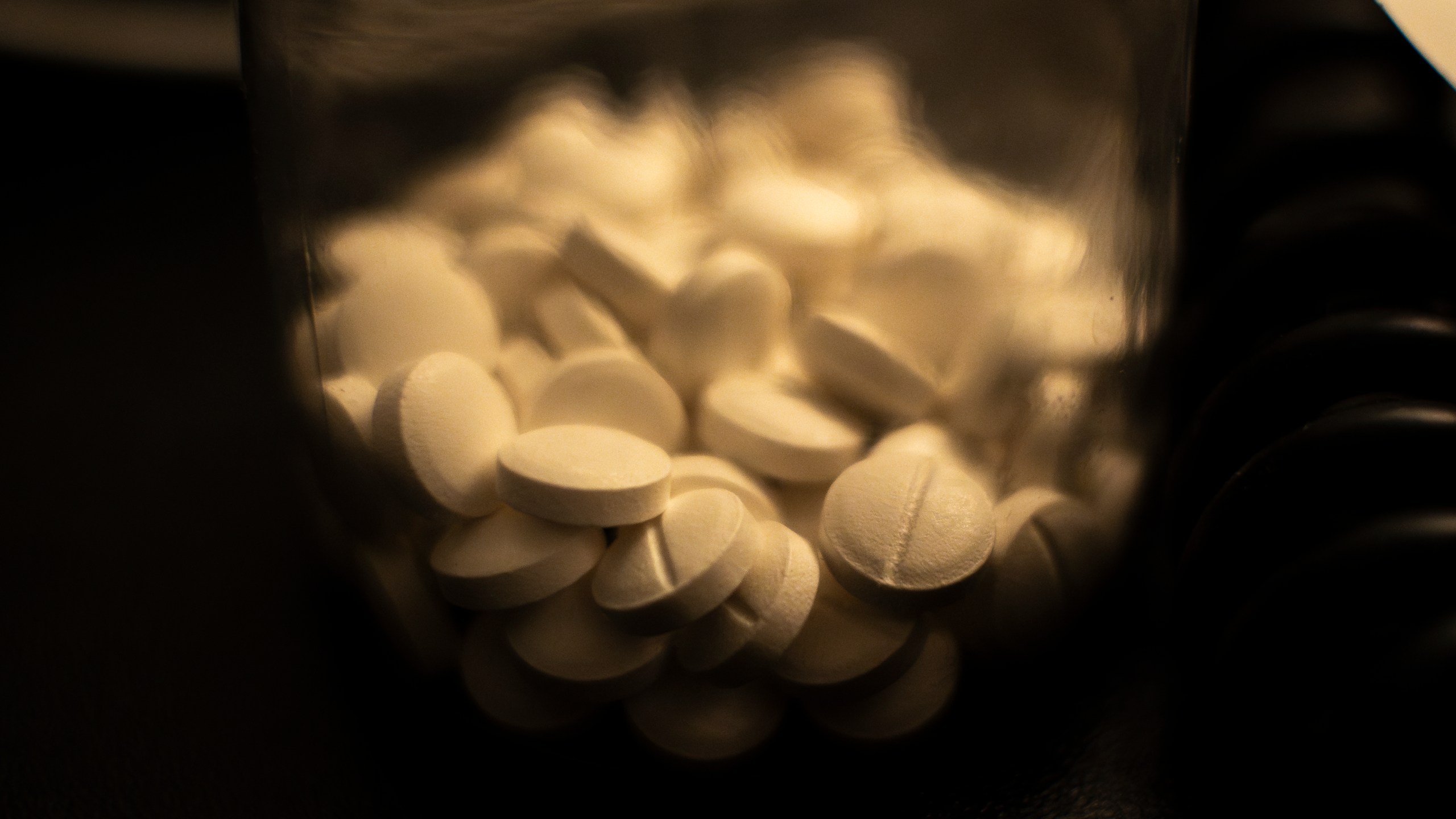 A plastic bottle with white colored antidepressant pills on a desktop