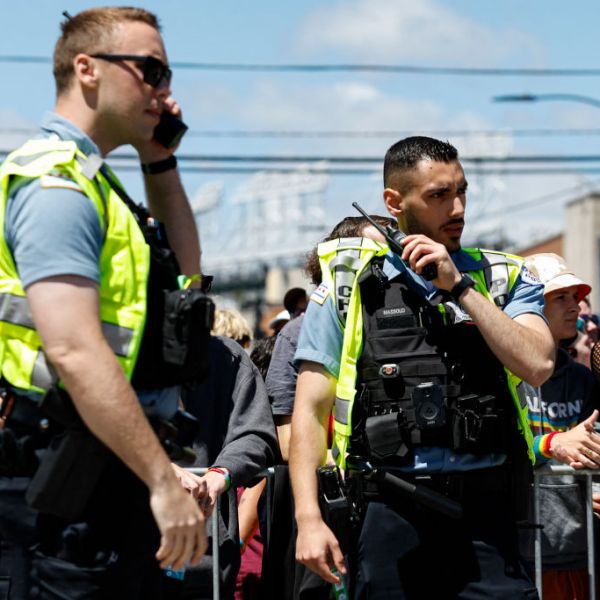 A Chicago police officer in a crowd speaks into his radio.