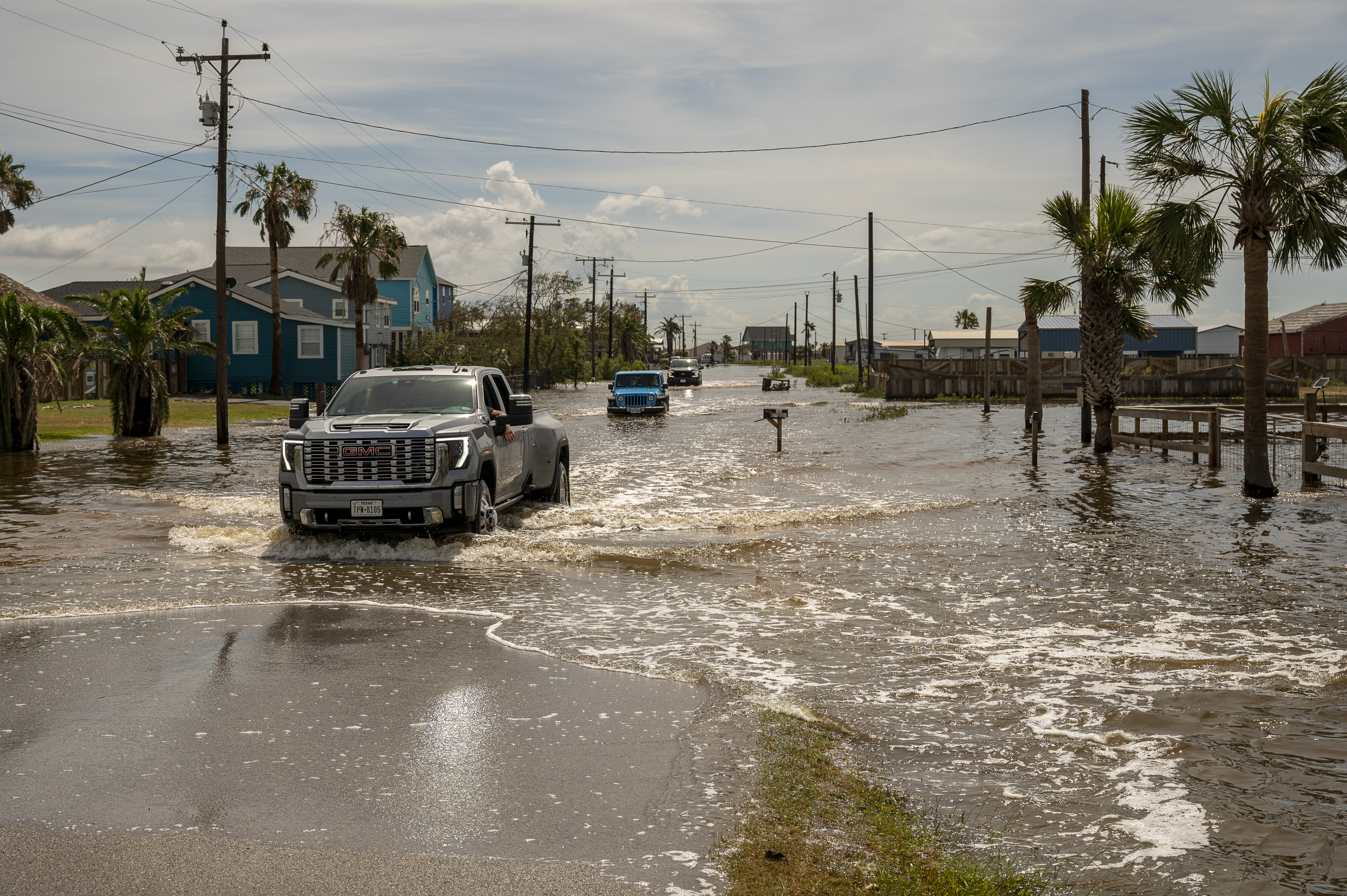 Vehicles travel through a flooded street after Hurricane Beryl made landfall in Sargent, Texas, US, on Monday, July 8, 2024.