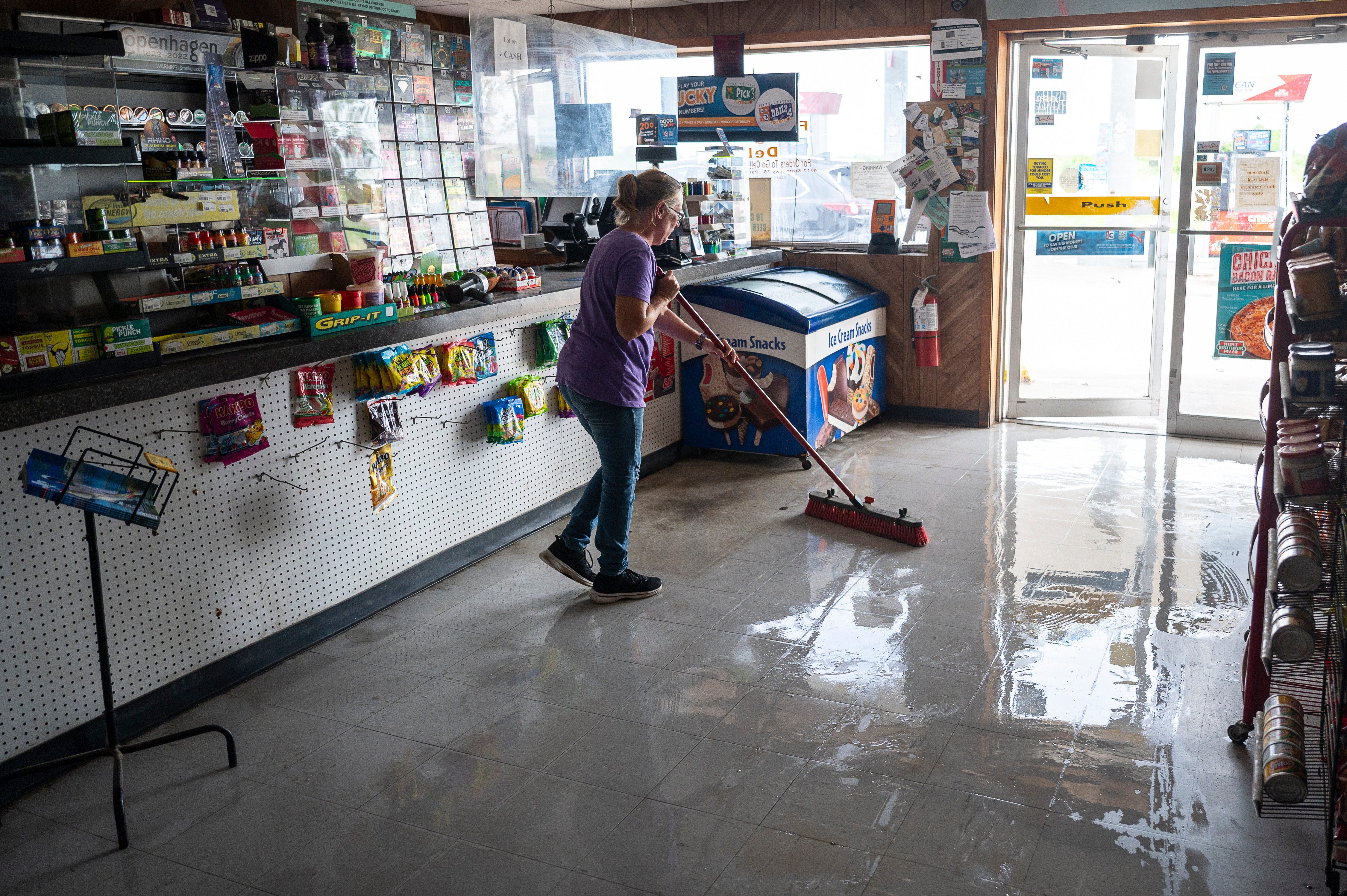 A worker sweeps water from a damaged convenience store after Hurricane Beryl made landfall in Palacios, Texas, US, on Monday, July 8, 2024.