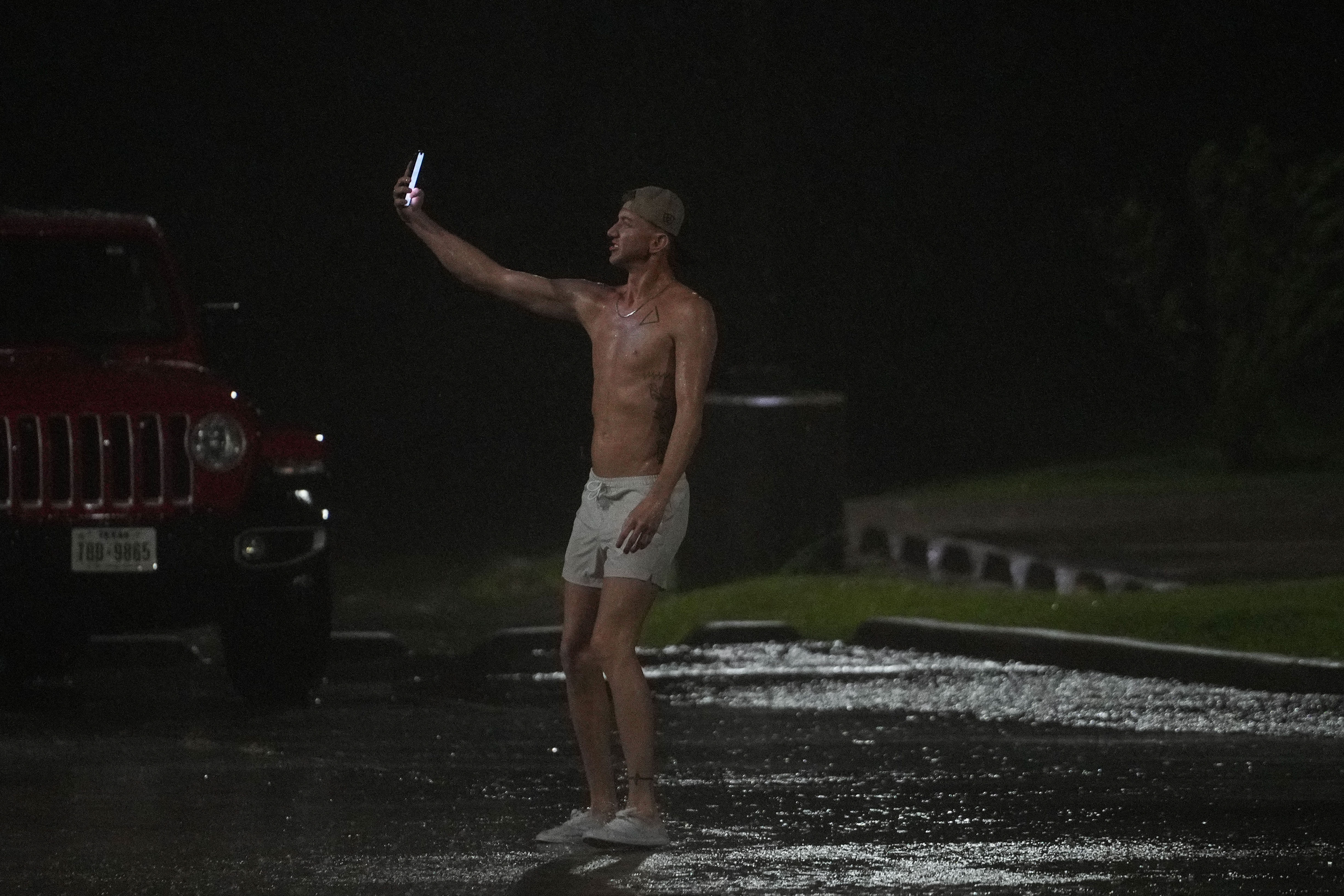 Brent Meads films himself as he stands in the heavy wind and rain from Hurricane Beryl on Monday, July 8, 2024, in Bay City.