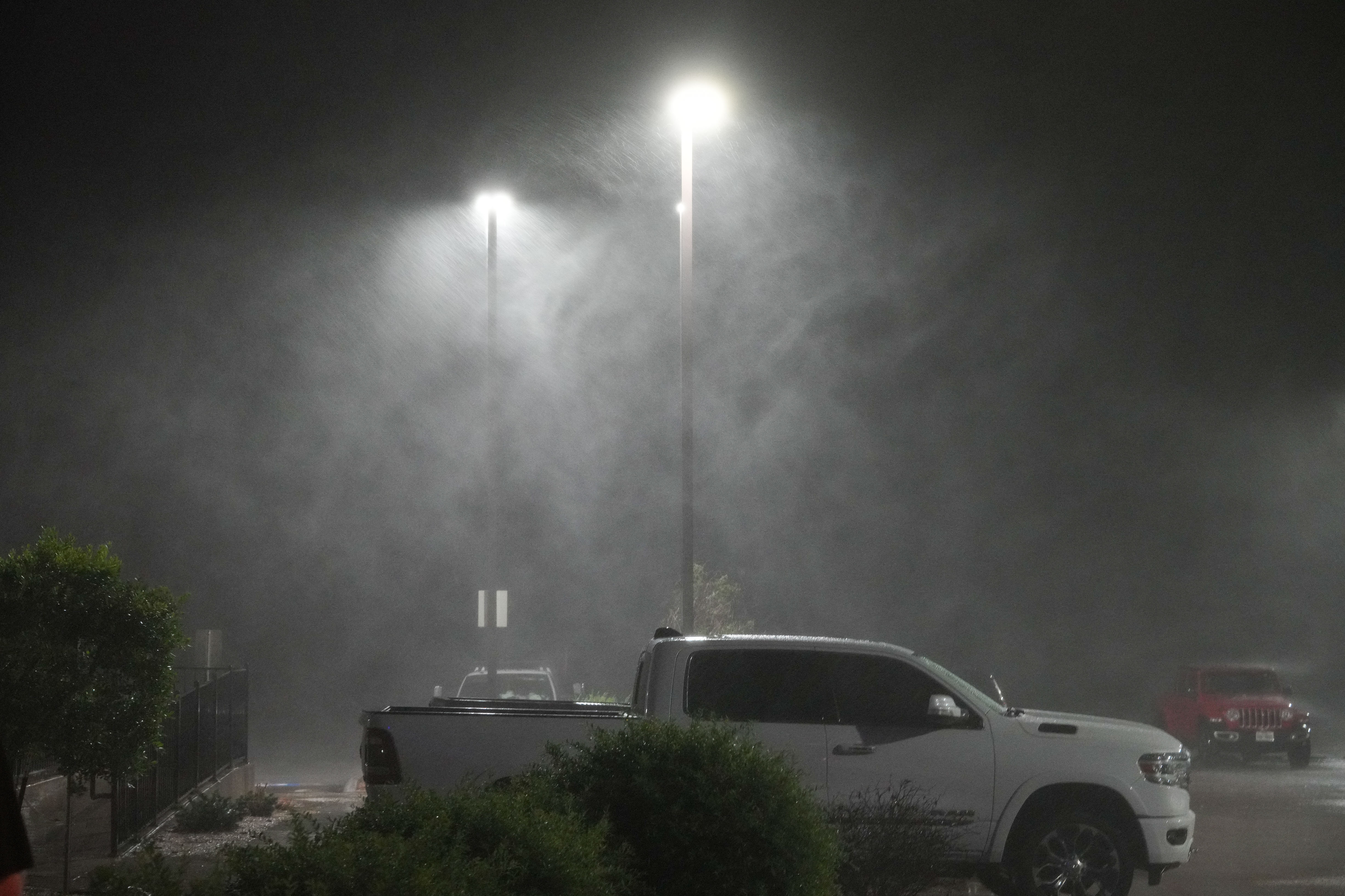 Heavy rain from Hurricane Beryl is illuminated by parking lot lights Monday, July 8, 2024, in Bay City.