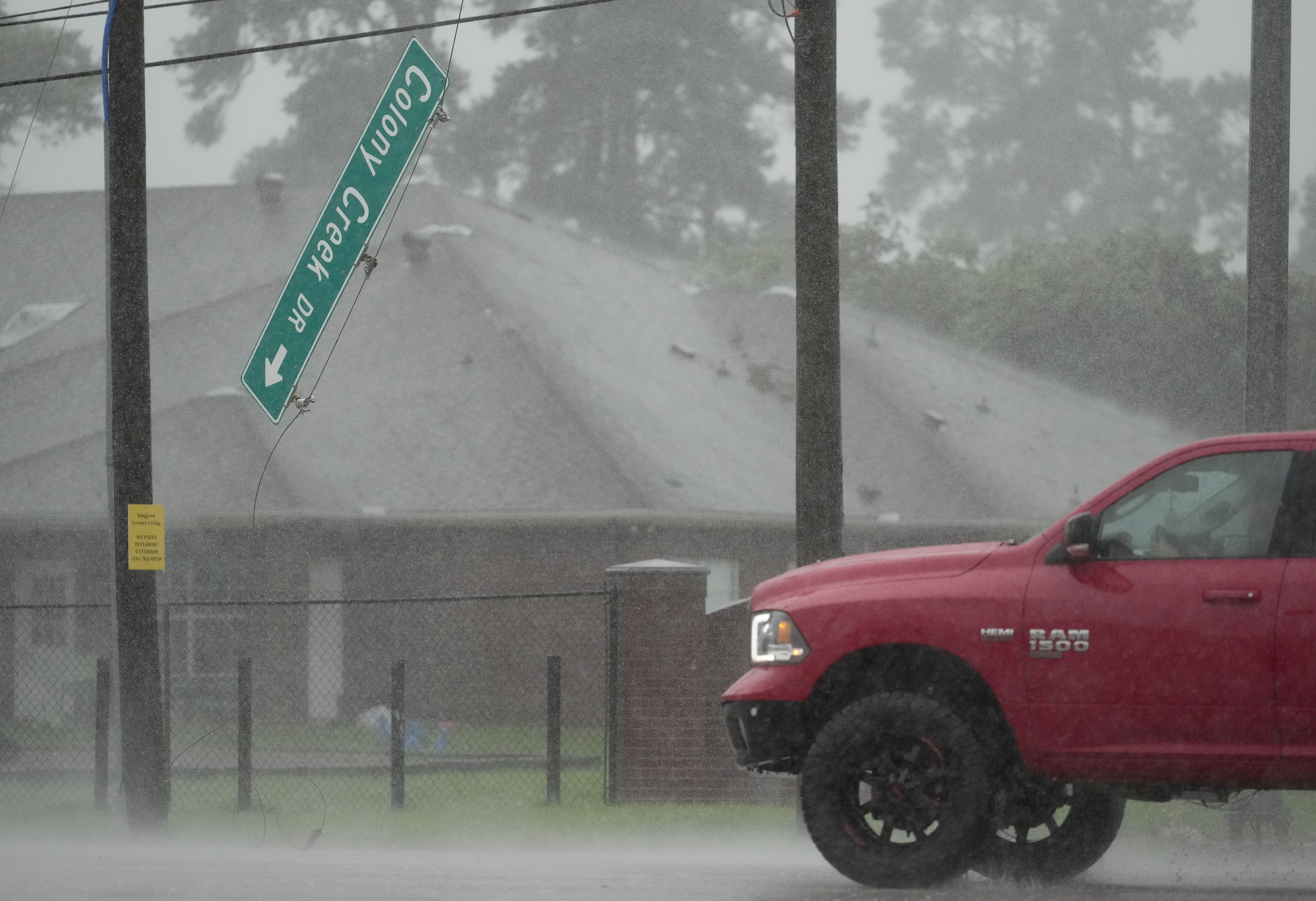 The Colony Creek Dr. street sign dangles at the intersection of Louetta Rd. during Hurricane Beryl Monday, July 8, 2024, in Spring.