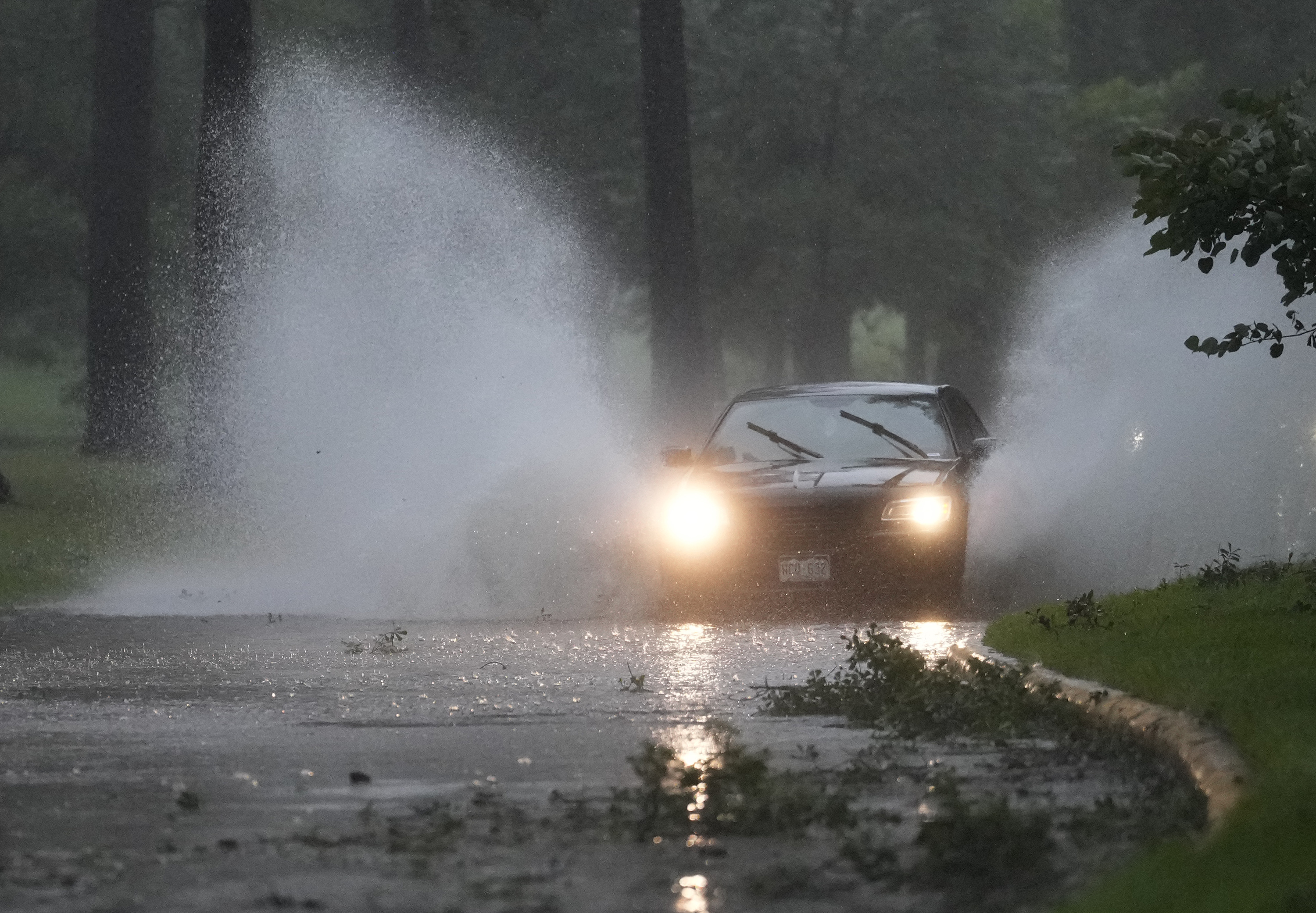 A vehicle maneuvers through high water and debris during Hurricane Beryl.