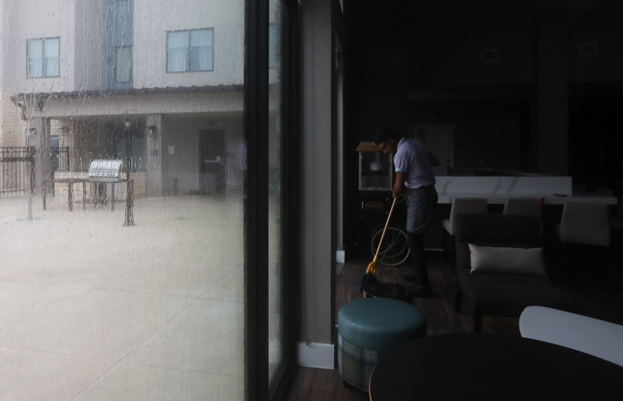 Andrew Parada, an employee at Residence Inn mops up the floor as water keeps leaking in during Hurricane Beryl on Monday, July 8, 2024 in Galveston.