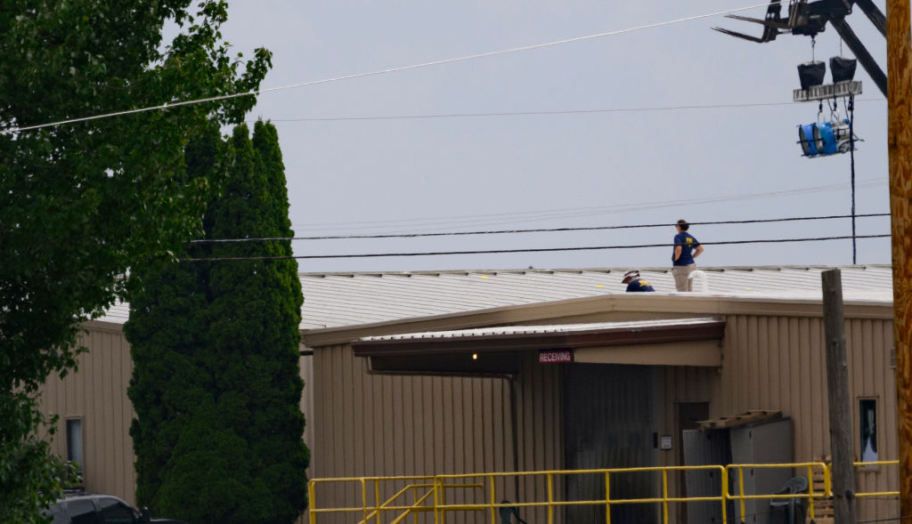 Two FBI investigators scan the roof of the building in Butler, Penn. from which a shooter fired at former President Donald Trump.