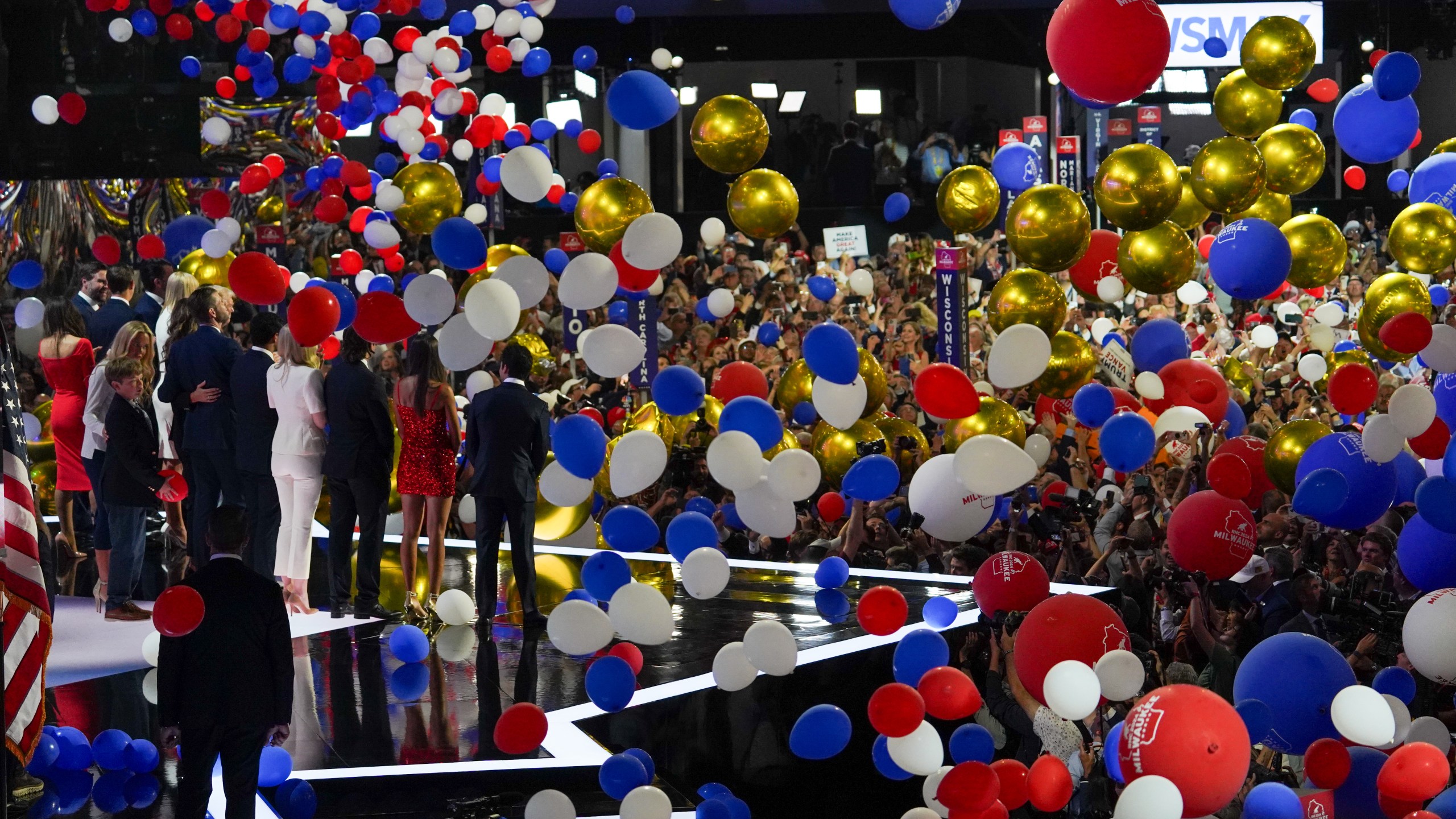 Former U.S. President Donald Trump and his family greet the crowd as red, white and blue balloons drop down at the Republican National Convention.