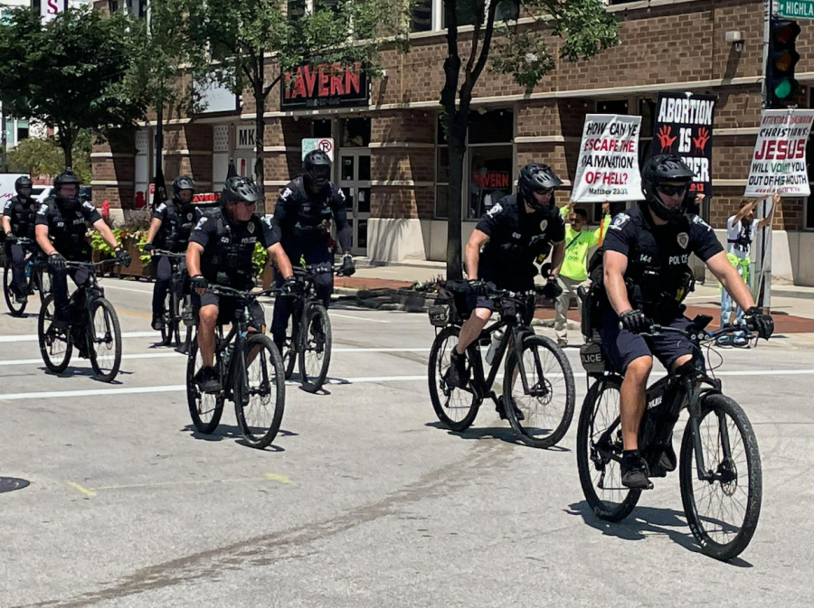 Police on bicycles ride down Milwaukee streets during the RNC.