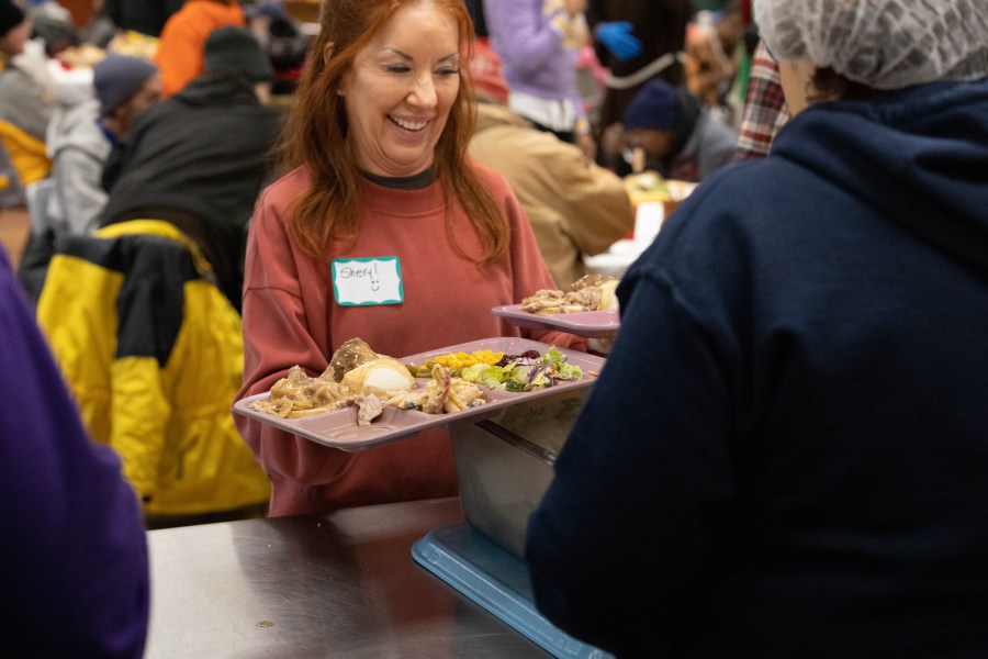 A picture of a woman serving meals to Milwaukee's homeless community.