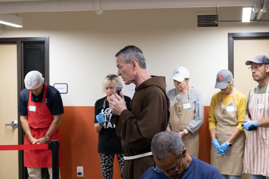 A priest prays over a meal served to Milwaukee's homeless population.