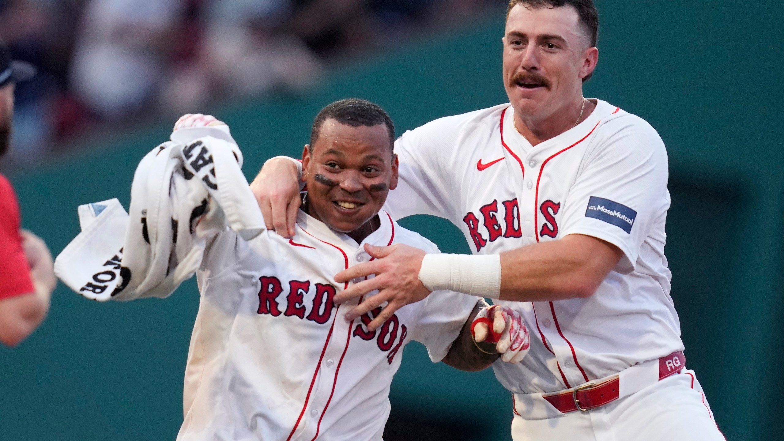 Boston Red Sox's Rafael Devers, left, celebrates after his game-winning RBI double, which drove in Tyler O'Neill, during the 10th inning of a baseball game against the Seattle Mariners, Wednesday, July 31, 2024, in Boston. At right is Boston Red Sox shortstop Romy Gonzalez. (AP Photo/Charles Krupa)