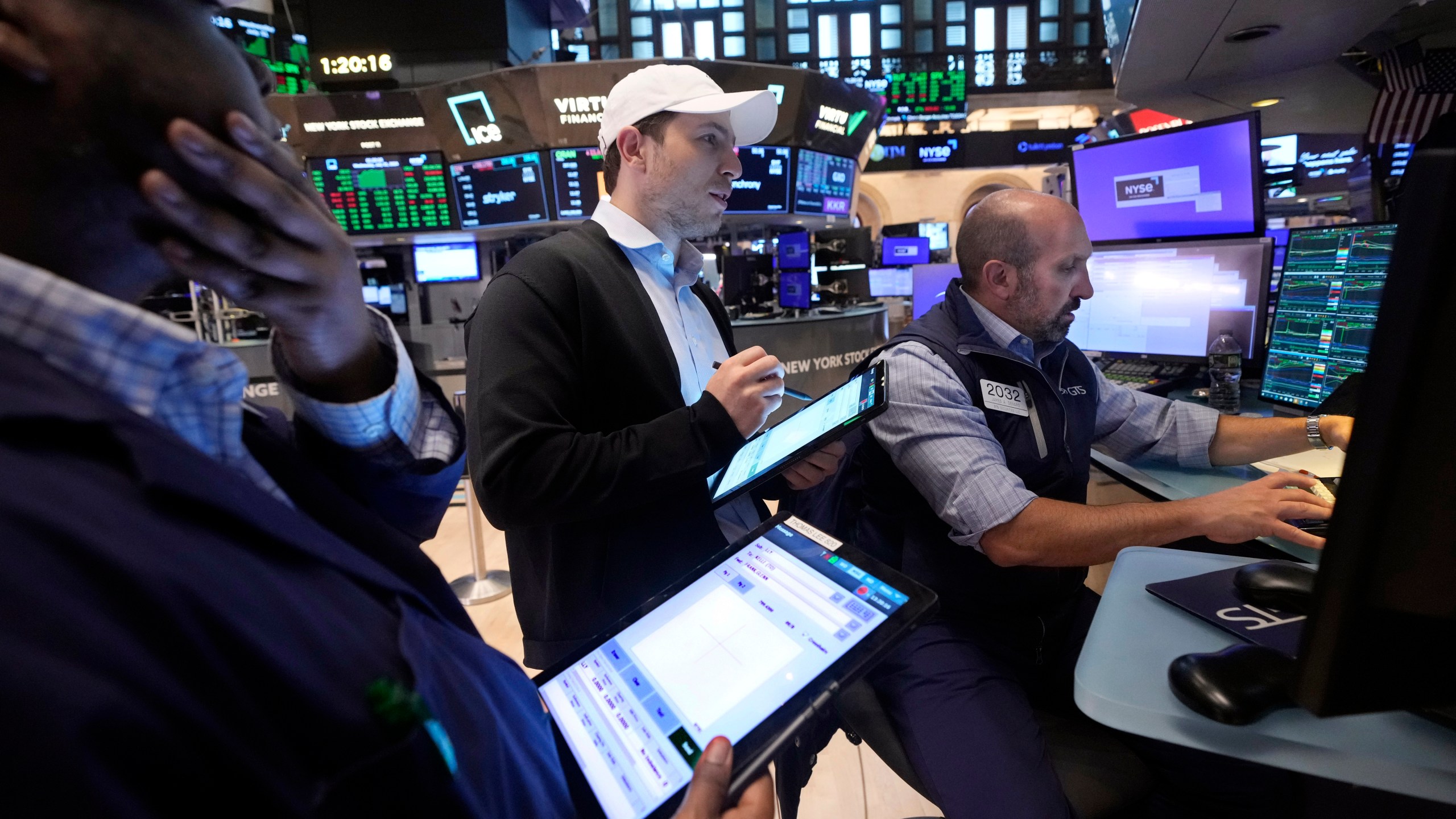 A pair of traders work at the post of specialist James Denaro, right, on the floor of the New York Stock Exchange, Wednesday, July 31, 2024. (AP Photo/Richard Drew)