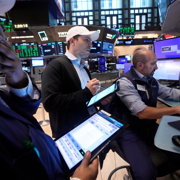 A pair of traders work at the post of specialist James Denaro, right, on the floor of the New York Stock Exchange, Wednesday, July 31, 2024. (AP Photo/Richard Drew)