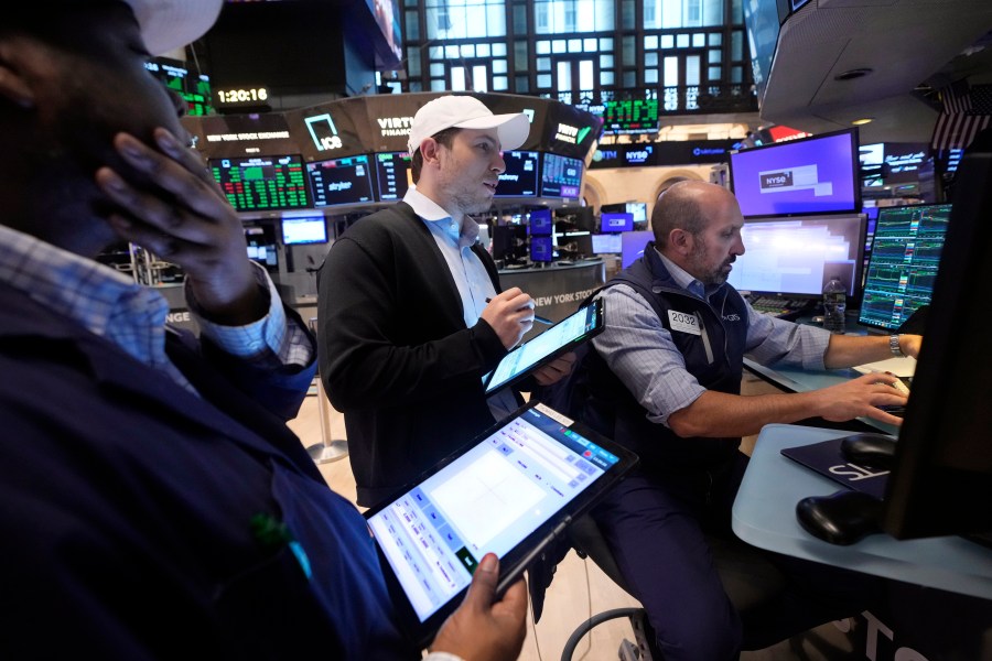 A pair of traders work at the post of specialist James Denaro, right, on the floor of the New York Stock Exchange, Wednesday, July 31, 2024. (AP Photo/Richard Drew)